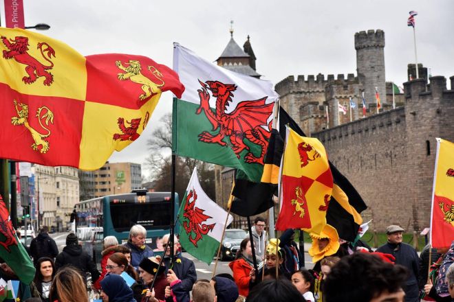 people waving Flags of scotland and saint david's day